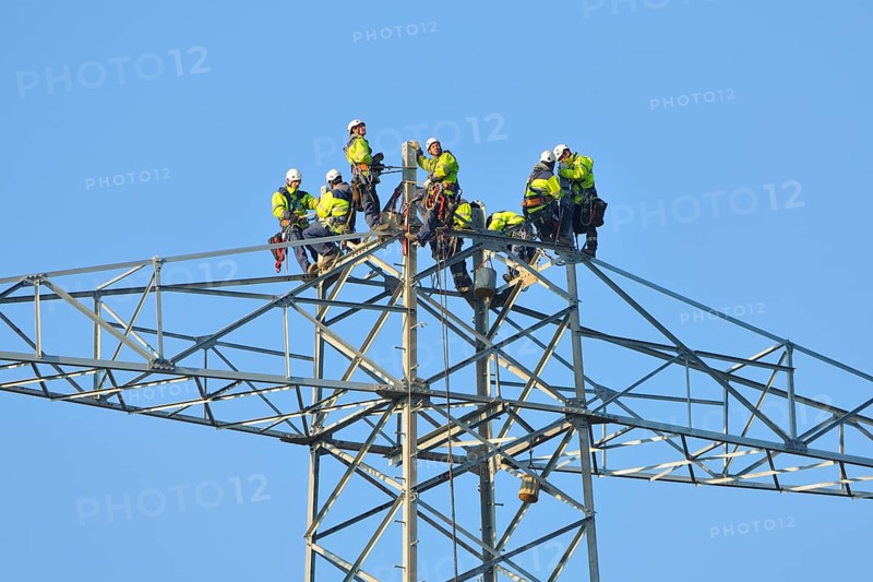 Overhead linemen working on a pylon