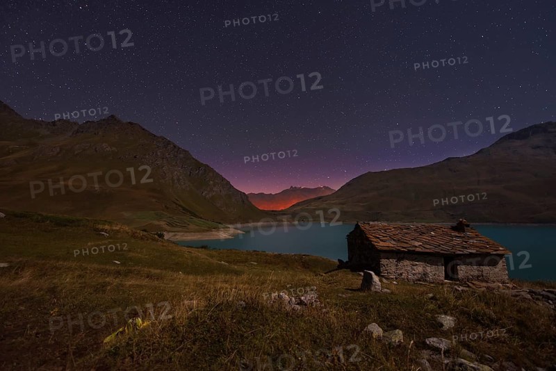 Night sky above Mont Cenis lake and a hut