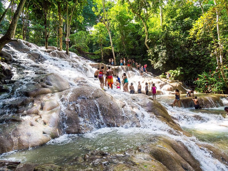 Tourists bathing and climbing the Dunn's River Falls