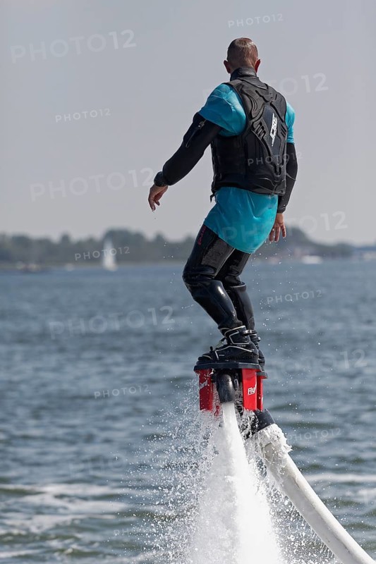 Flyboarder on the water jet of a jet ski