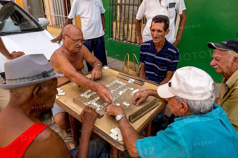 Cuban men playing dominoes at a table outside