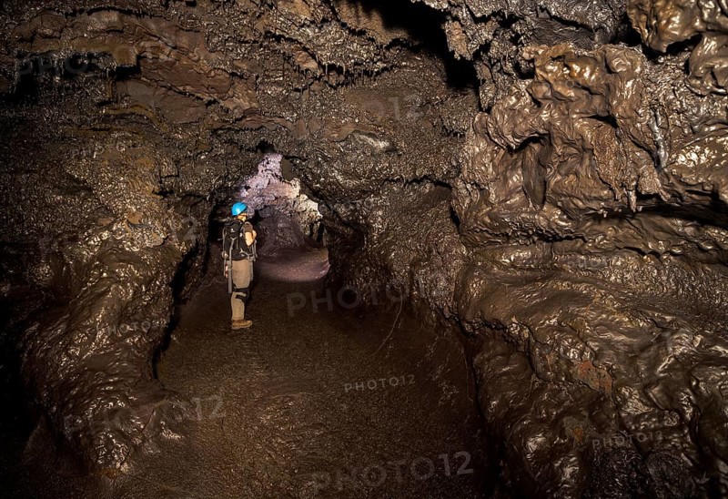 Tourist standing in a subterranean lava tube created by an eruption of the Piton de la Fournaise volcano