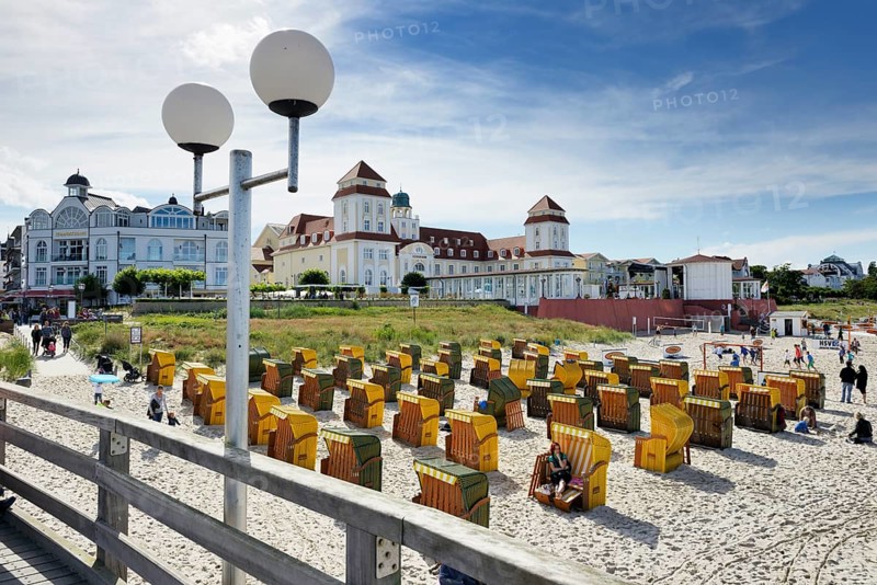Roofed wicker beach chairs in front of the Kurhaus spa building