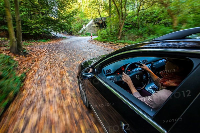 Car driving on a street covered with leaves