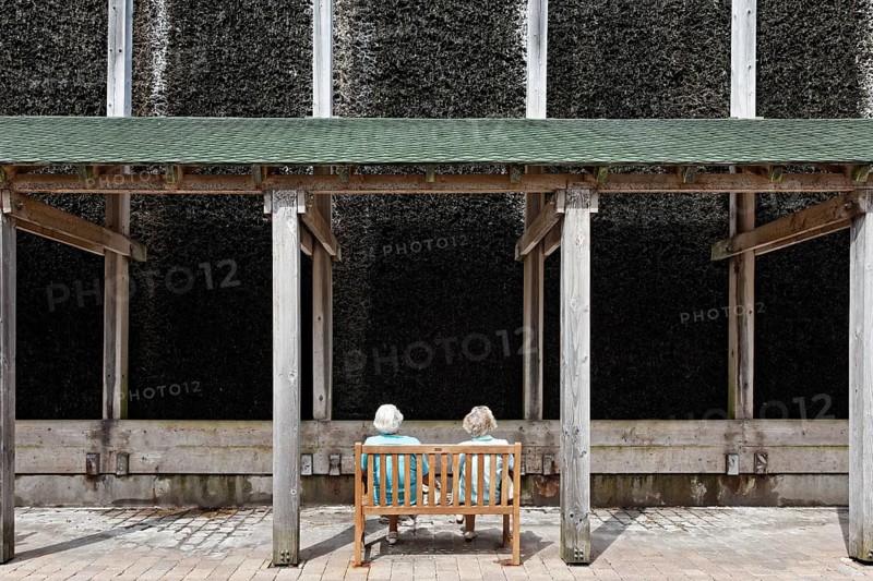 Two seniors sitting in front of a graduation works for the inhalation of salty air