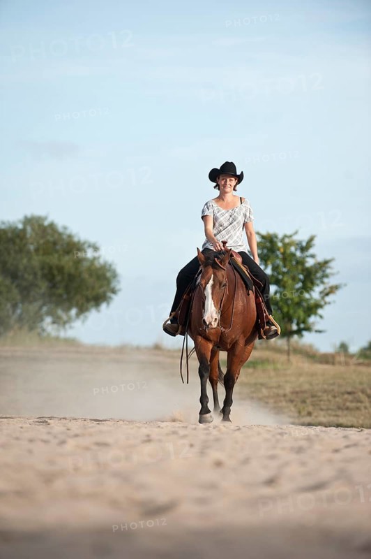 Woman riding a trotting Quarter Horse