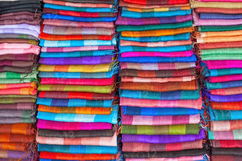 Colourful silk textiles on display at a market stall in Luang Prabang