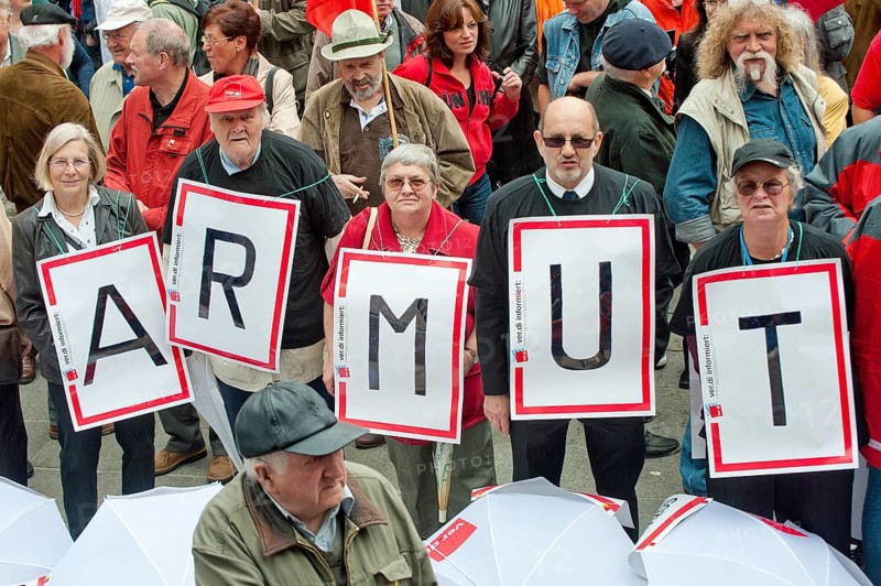 Senior citizens holding protest posters spelling out the word 'Armut'