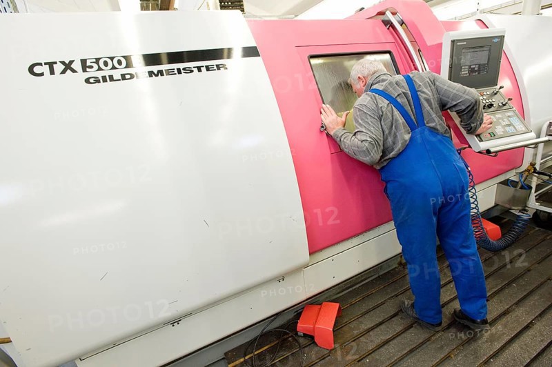 Lathe operator using a CNC Gildemeister turning lathe