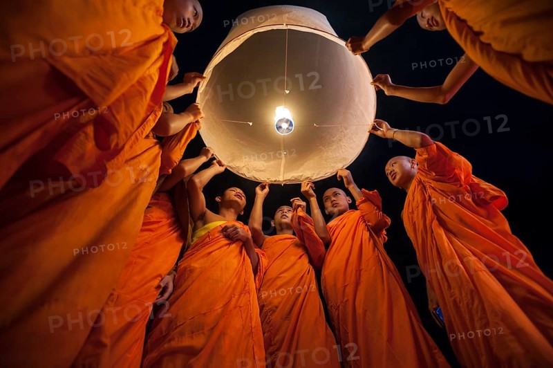 Monks releasing a Kongming lantern or sky lantern for luck during the Loi Krathong or Loy Gratong Festival