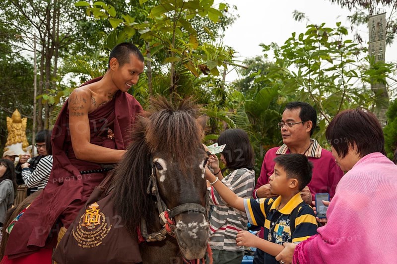 Buddhist monk on horseback collecting alms in the morning