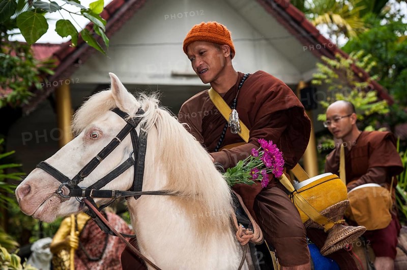 Buddhist monk on horseback collecting alms in the morning