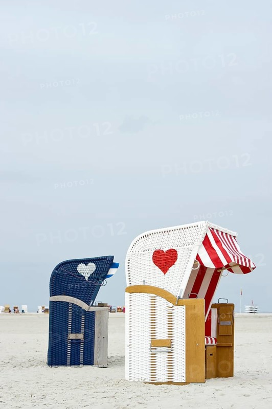 Roofed wicker beach chairs with hearts on the beach at Norddorf