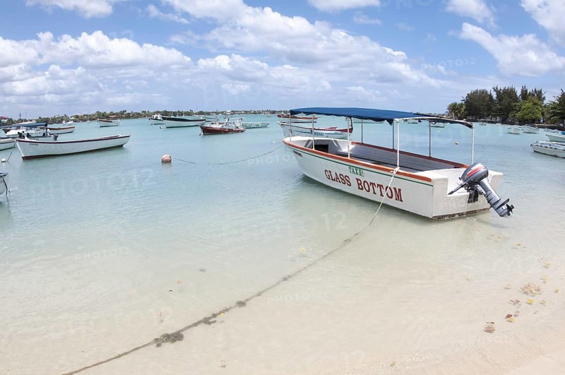 Glass bottom tourist boat moored beside sandy beach