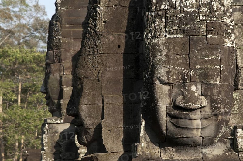 Large sculptures of heads on tower of Khmer temple