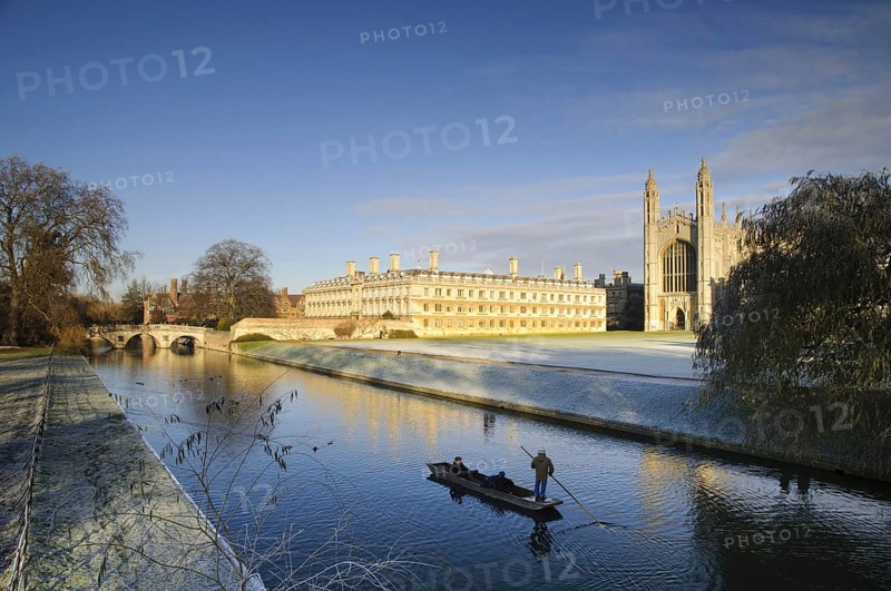 View of river with punt approaching bridge and college buildings in frost