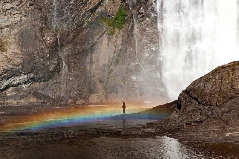 Angler in front of the waterfall