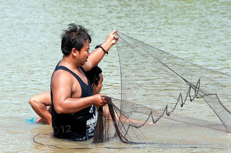 Fishermen putting out a fishing net in the Sangkae river
