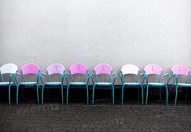 A row of pink chairs in front of an Italian ice cream parlor