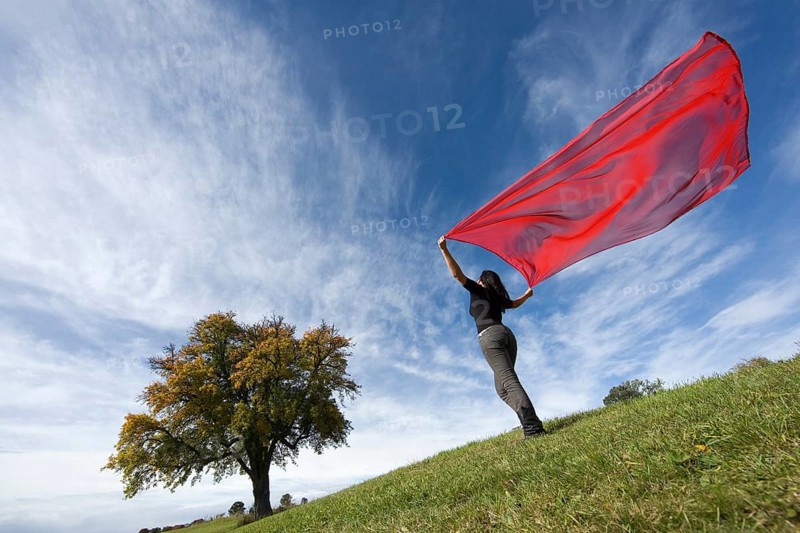 Oblique side view of a young woman standing on a meadow
