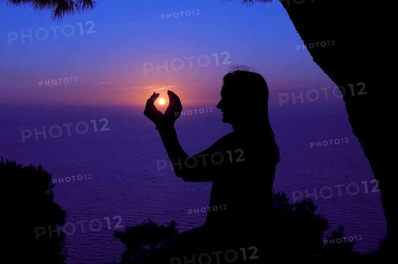 Silhouette of a woman against the sunset sky