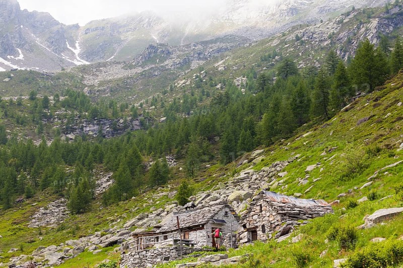 Man arriving at a few mountain huts while hiking