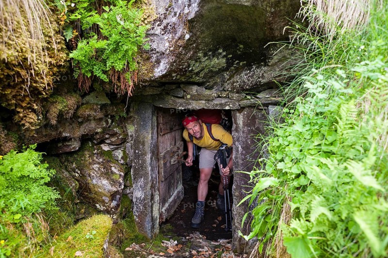 Man looking out of a rock cellar