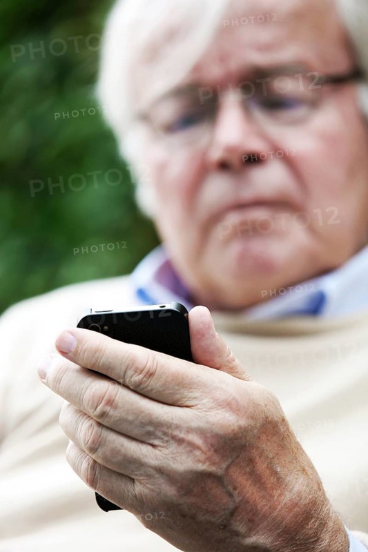 Senior holding a smartphone in his hands