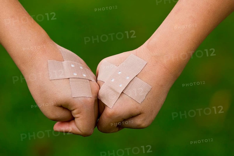 Children's hands with plaster strips