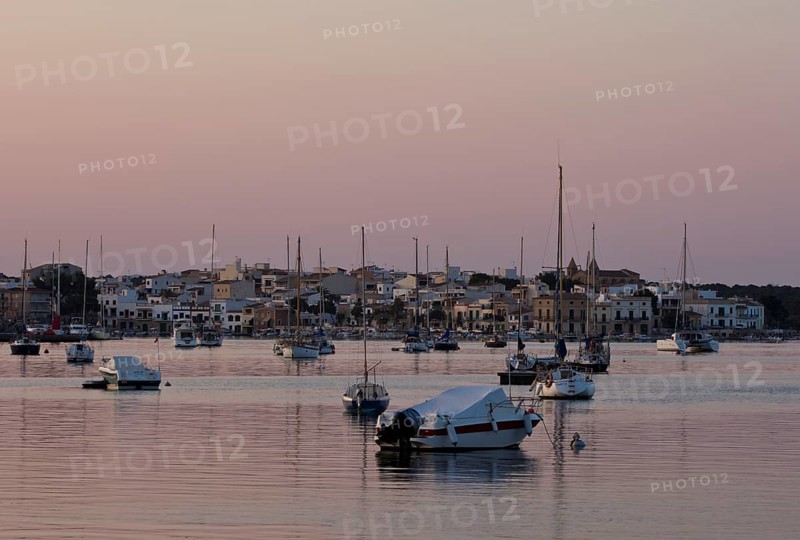 Sailing boats in a harbour at sunset
