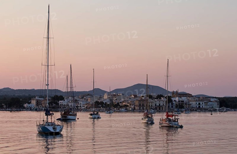 Sailing boats in a harbour at sunset