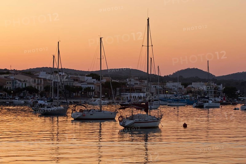 Sailing boats in a harbour at sunset