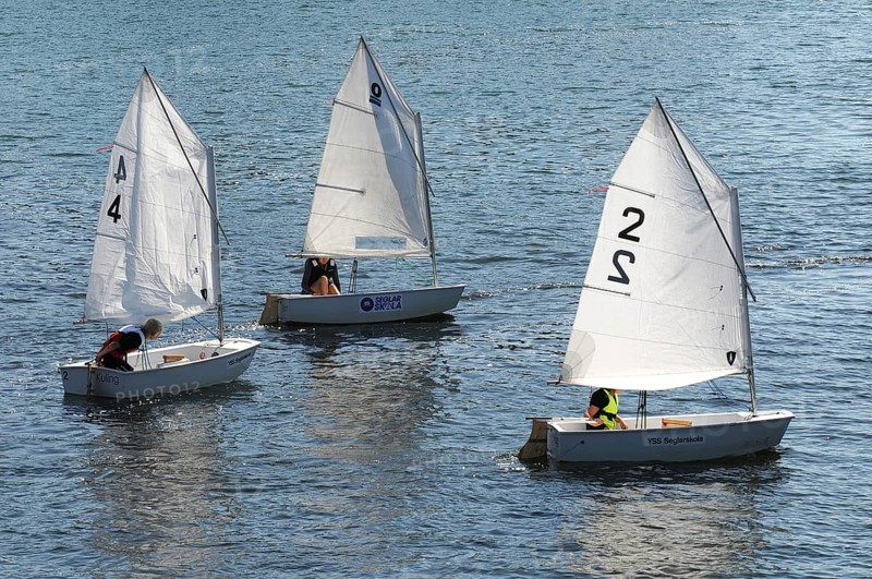Three Optimist dinghies in a sailing school