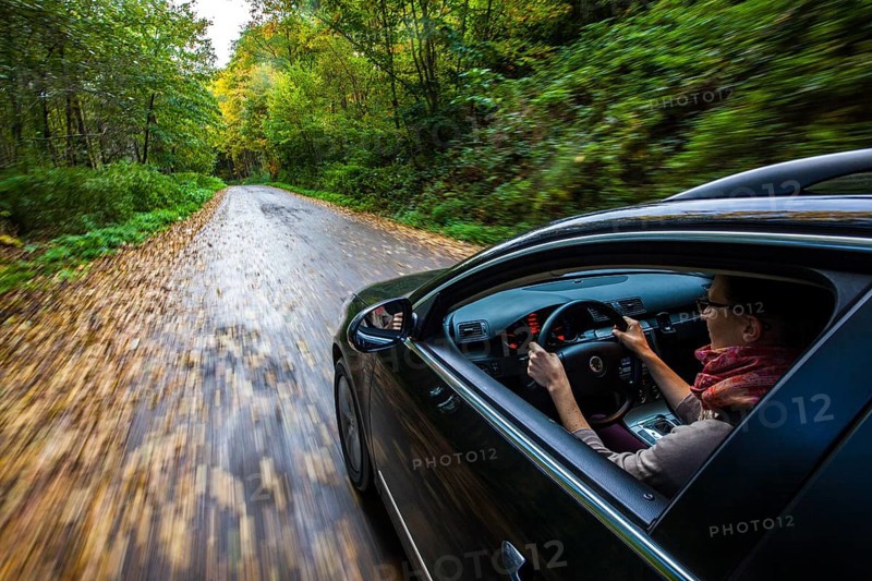 Car driving on a street covered with leaves