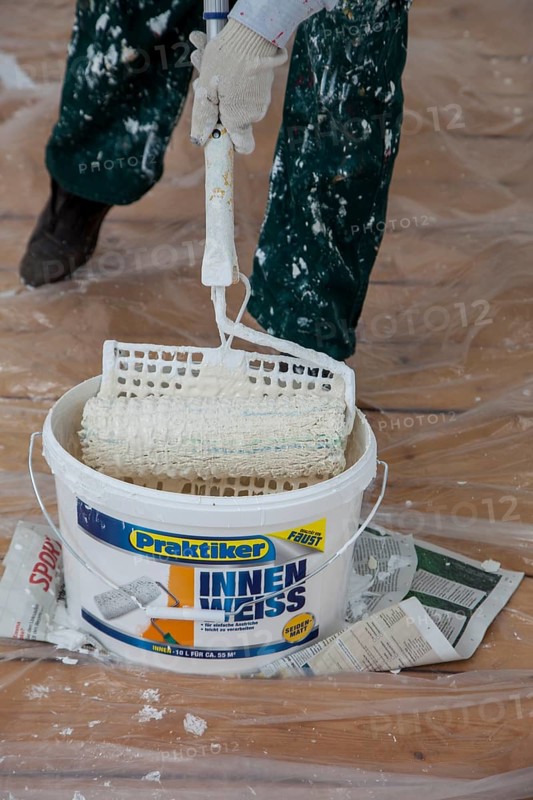 Bucket of paint and a paint roller for painting the walls
