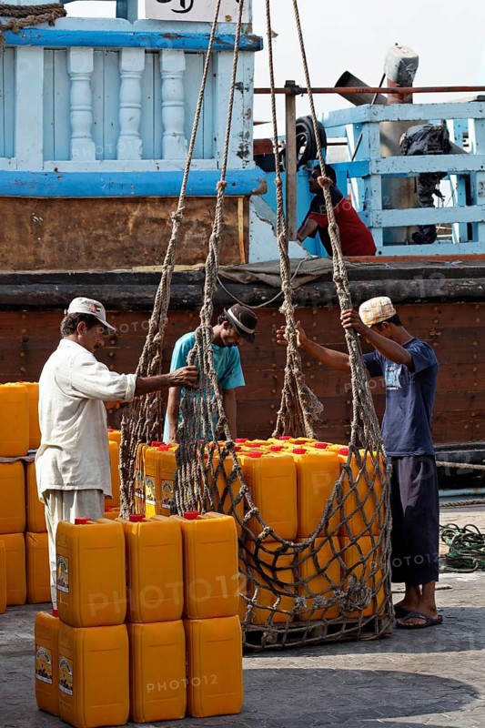 Loading cargo on an old wooden cargo ship