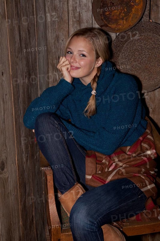 Smiling young woman with a blanket in a hiking hut