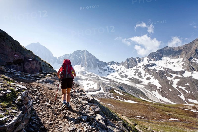 Hiker on the Merano High Mountain Trail ascending to Hohen Wilden Mountain in Pfossental valley