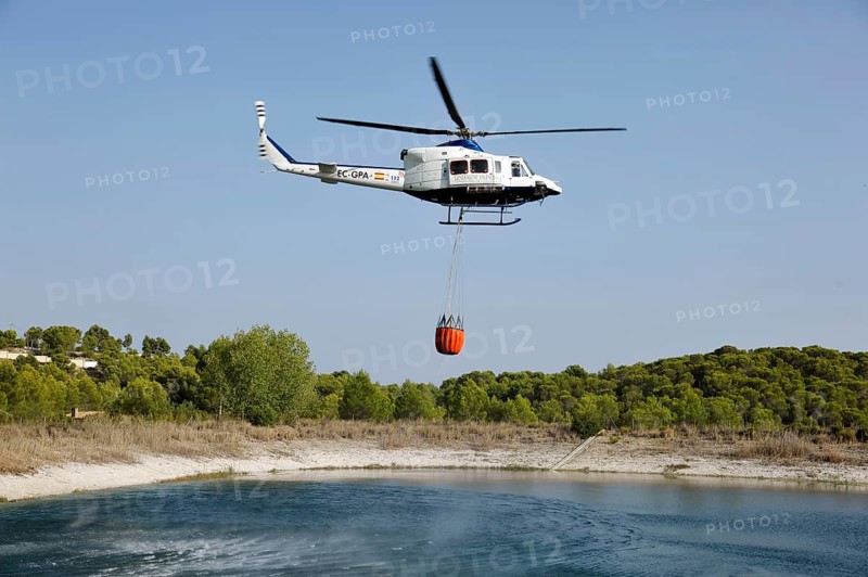 Fire helicopter getting water from a small artificial lake near Altea La Vella