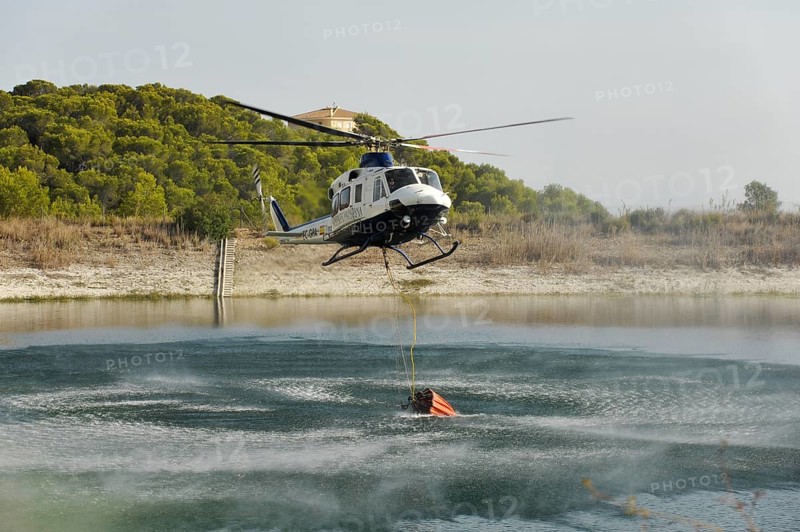 Fire helicopter getting water from a small artificial lake near Altea La Vella