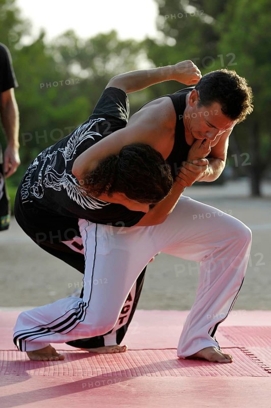 A man and a woman doing martial arts in a park