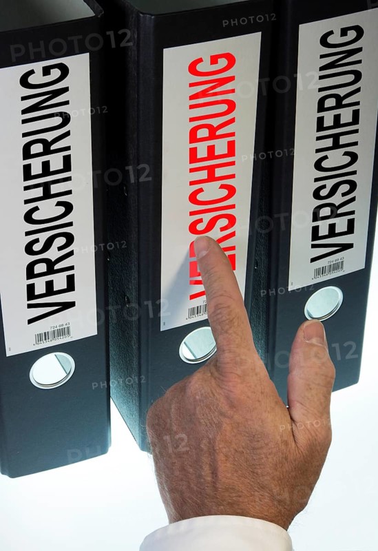 Hand pointing to a ring binder labelled 'VERSICHERUNG'