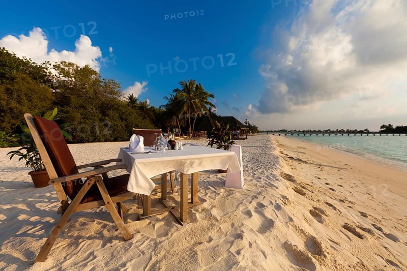 A table laid for dinner standing on the beach