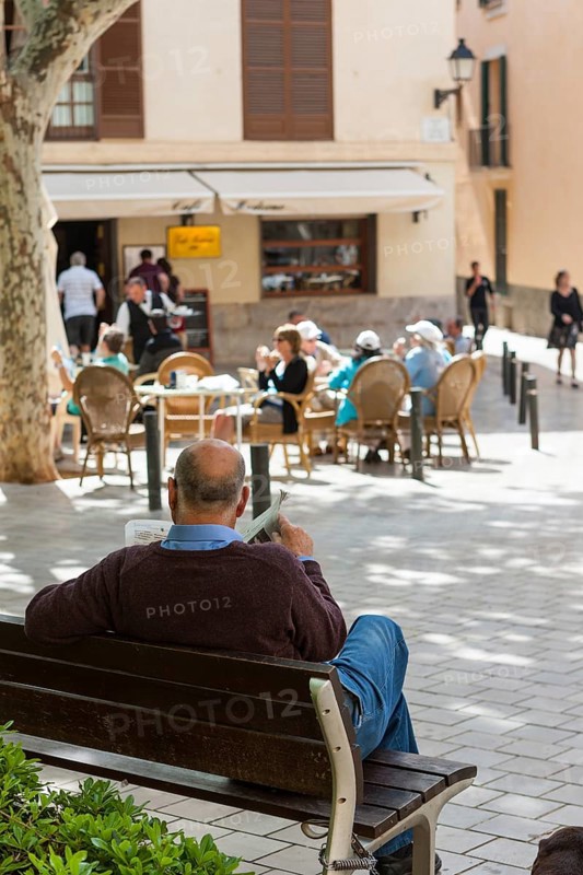 Spaniard reading a newspaper on Plaça de Santa Eulalia square