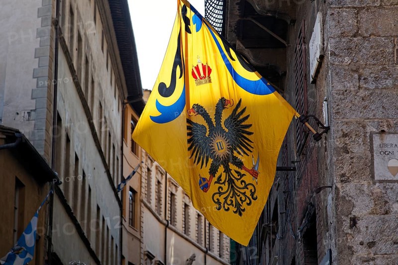Flag of a contrada district in an alley of the historic town centre