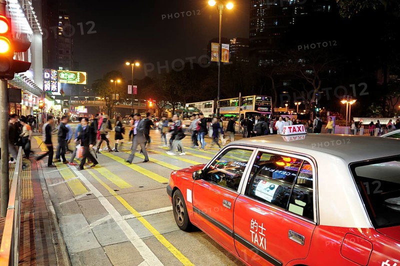 A red taxi waiting at a zebra crossing on Chatham Road in the evening