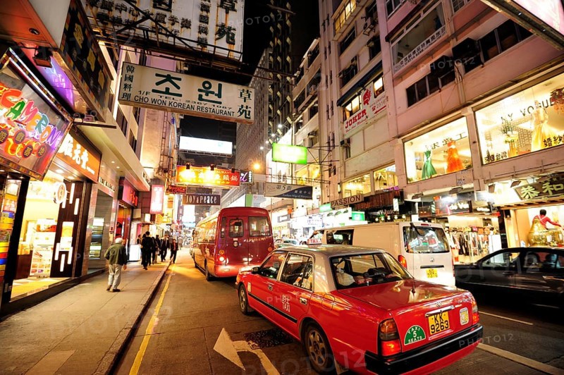 A red taxi on a street in the Tsim Sha Tsui district in the evening