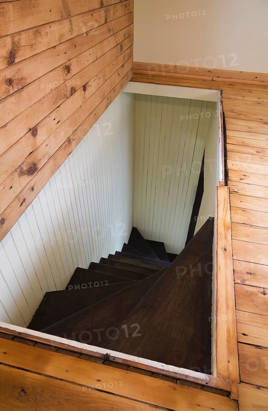 Trap door for wooden staircase leading to the downstairs floor of an old Canadiana cottage style residential home