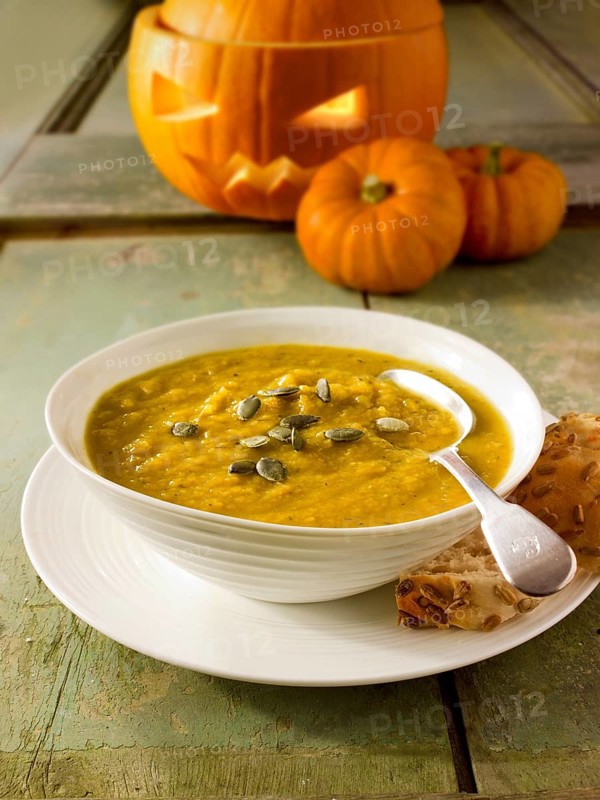 Pumpkin and bacon soup with a traditional Halloween pumpkin with a carved face