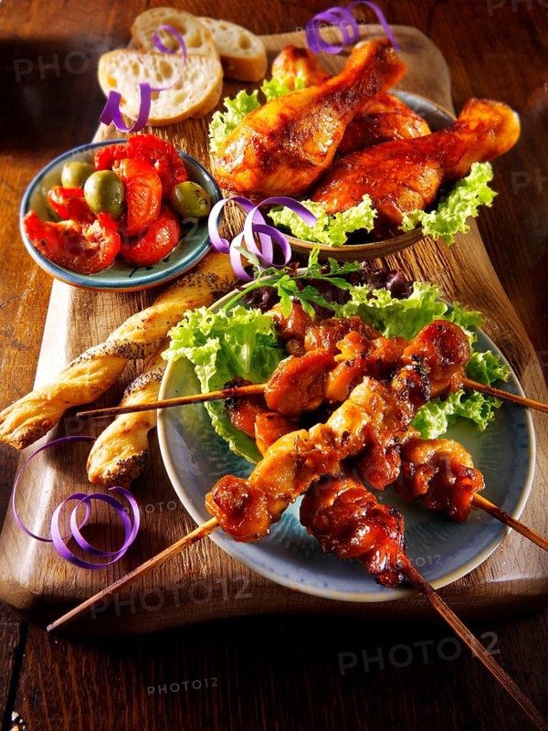 Party buffet food with chicken satay and BBQ drum sticks